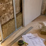 Optima Placostil : ponts thermiques sur mur irrégulier, rails métal et plaques de plâtre.